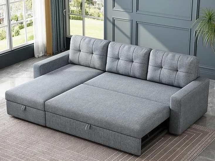 Grey sofa-cum-bed opened out flat in a panelled room.