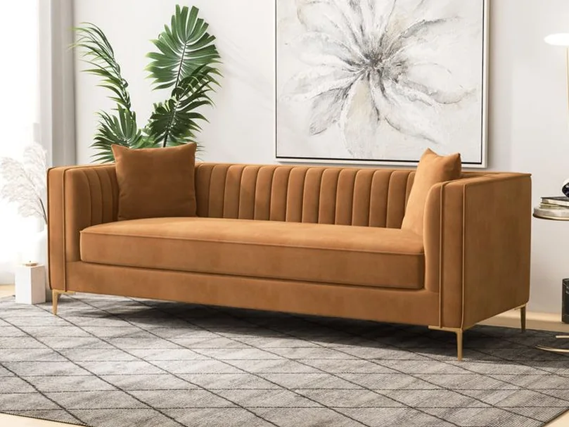 Tan suede three-seater sofa with brass legs.