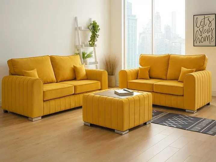 Mustard yellow sofa set with two armchairs and an ottoman.
